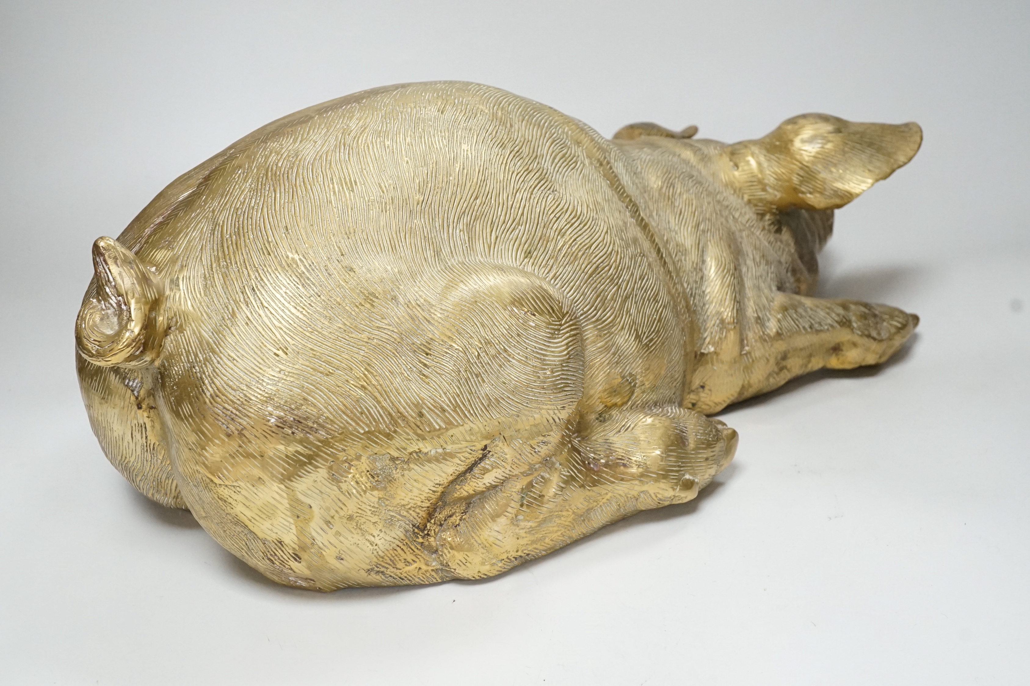 A large hollow cast brass model of a recumbent pig, 47cm long